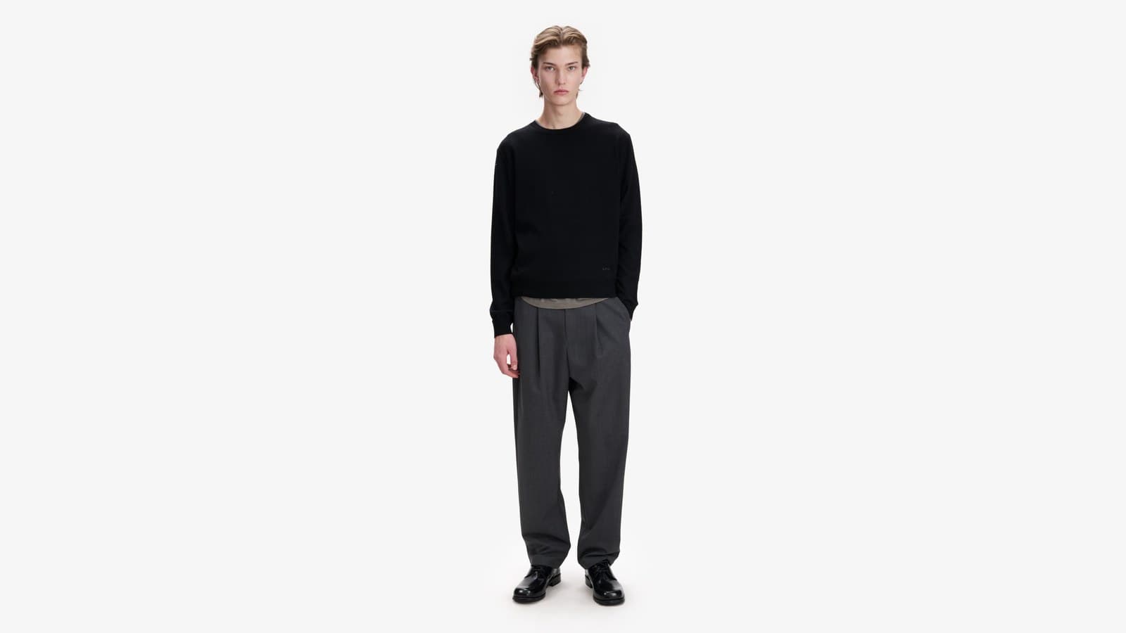 Homme en pull de laine mérinos noir A.P.C. et pantalon gris