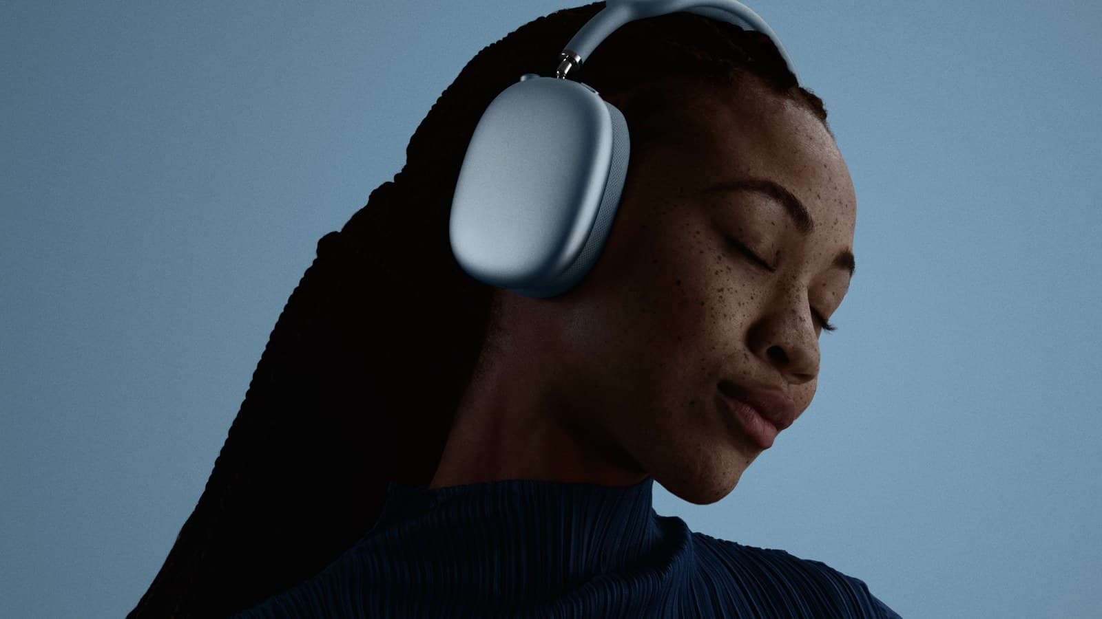 Femme portant un AirPods Max 2 bleu sur fond bleu