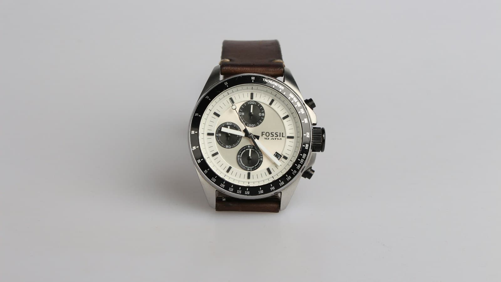 Montre chronographe a bracelet cuir posee sur un fond clair
