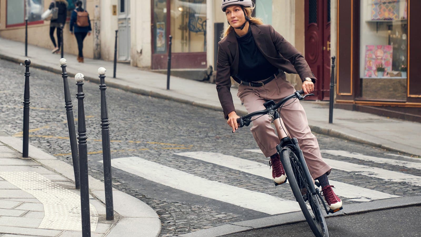 Cycliste sur un Riese & Müller UBN Seven dans une rue pavée