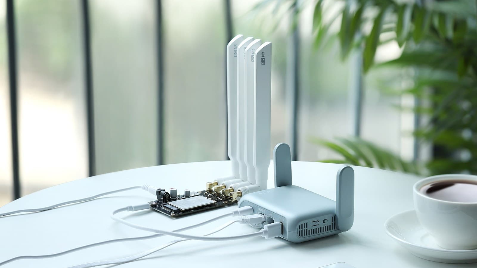 Petit routeur de voyage bleu posé sur un bureau de chambre d'hôtel, relié à une batterie externe par un câble USB-C