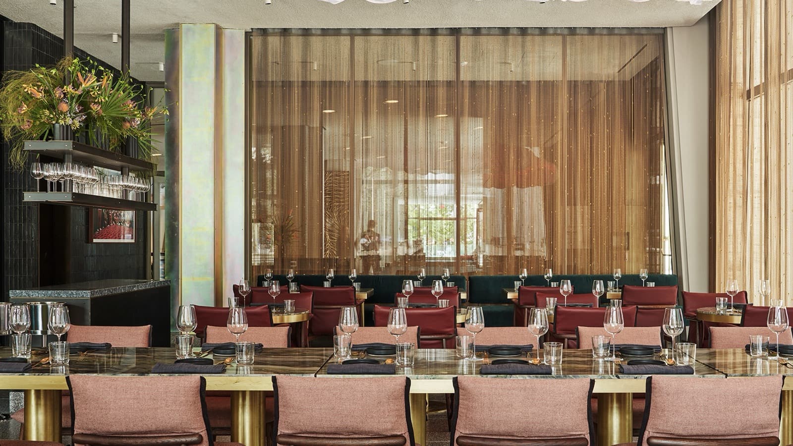 La salle de Tatiana à Lincoln Center, chaises rose poudré, tables de marbre cerclées de laiton et rideau de chaînes dorées