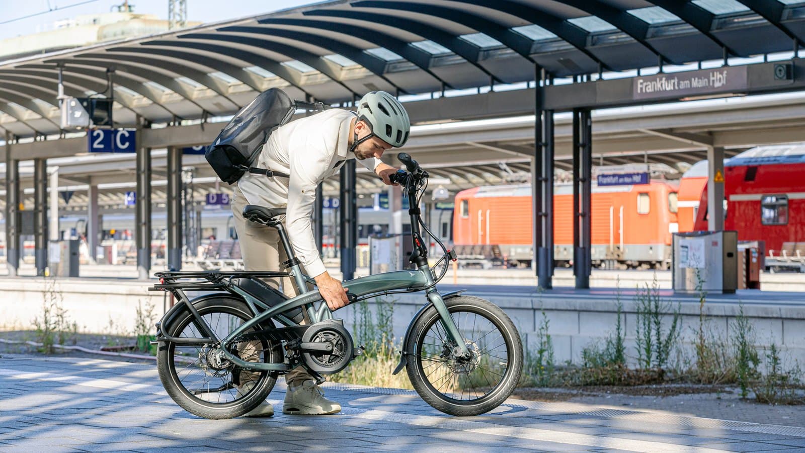 Homme pliant un Tern Vektron sur un quai de gare