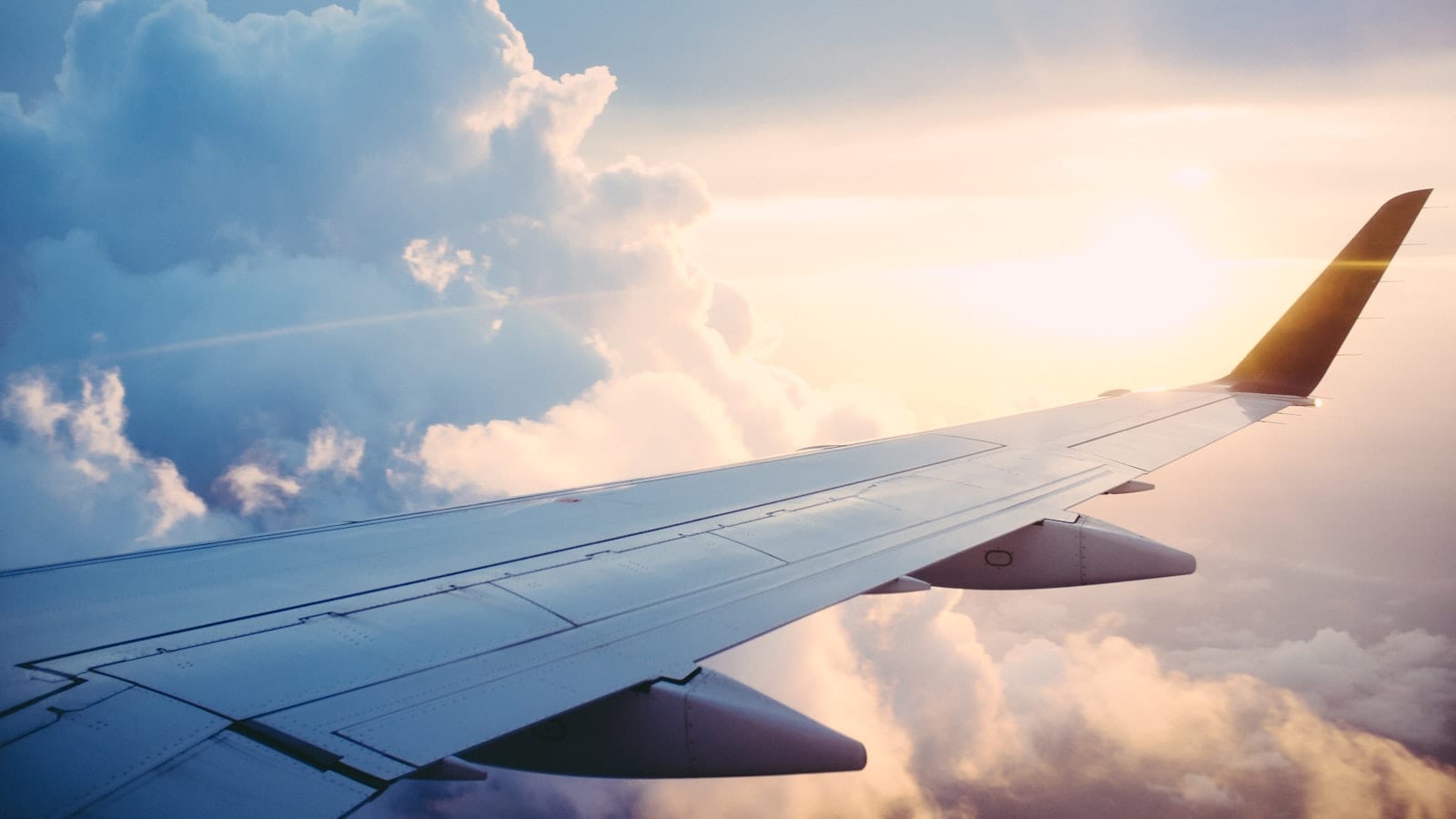 Ordinateur portable ouvert sur une tablette de siège en cabine, indicateur de mode avion affiché dans la barre de menus, dossier de travail visible à l'écran