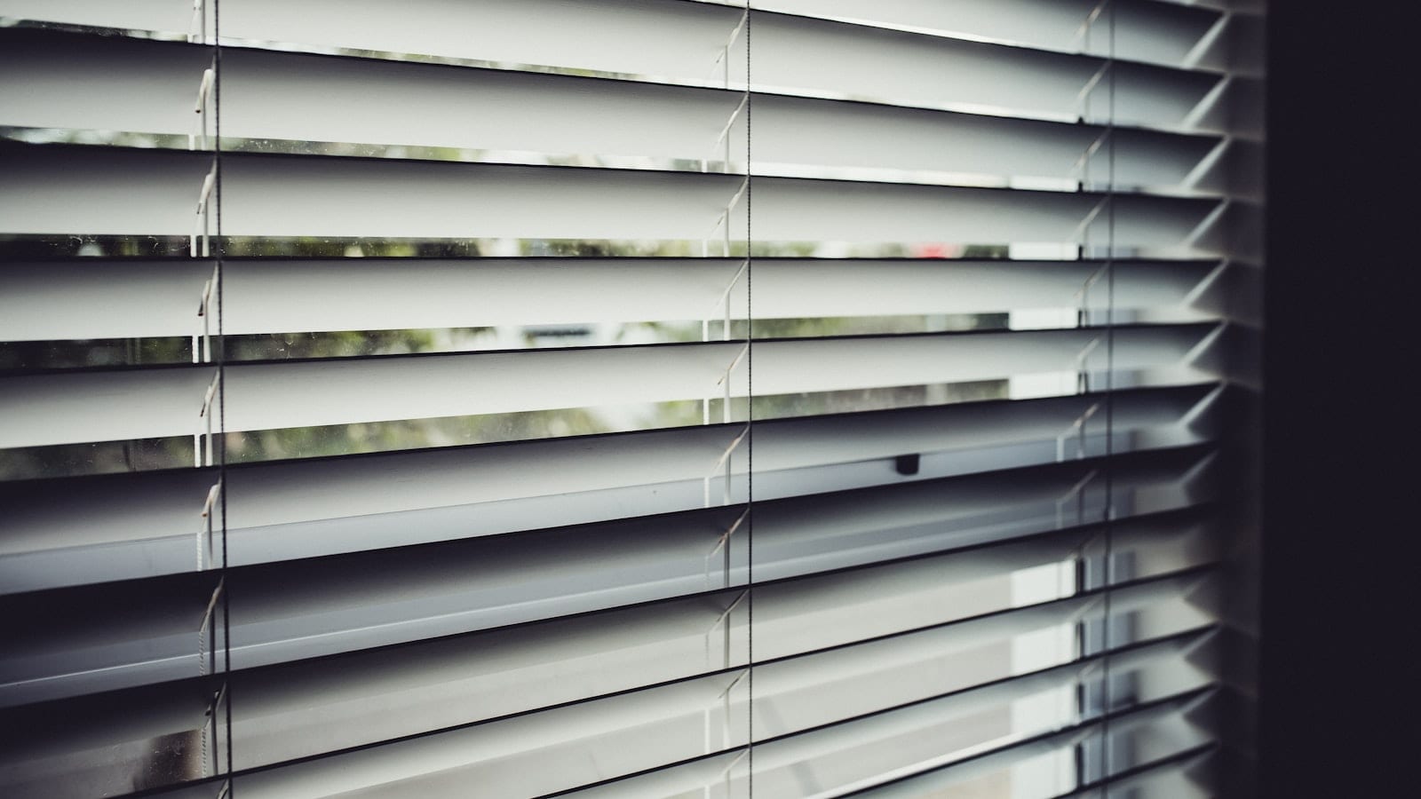 Écran d'ordinateur affichant un menu de paramètres de confidentialité avec plusieurs interrupteurs, dont un en cours de désactivation, dans un bureau éclairé de biais.