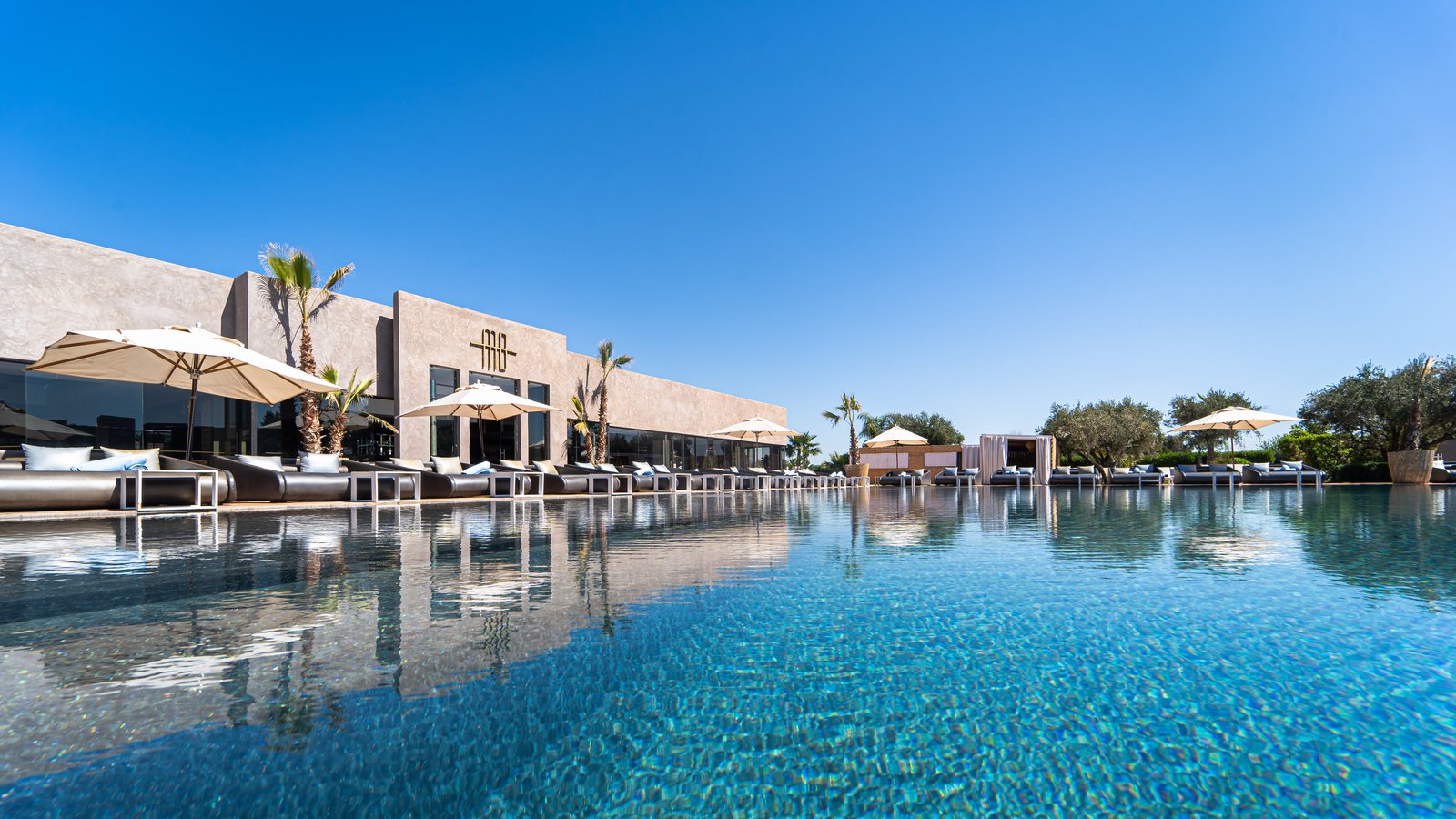 La grande piscine de Myah Bay bordée de transats, à Marrakech