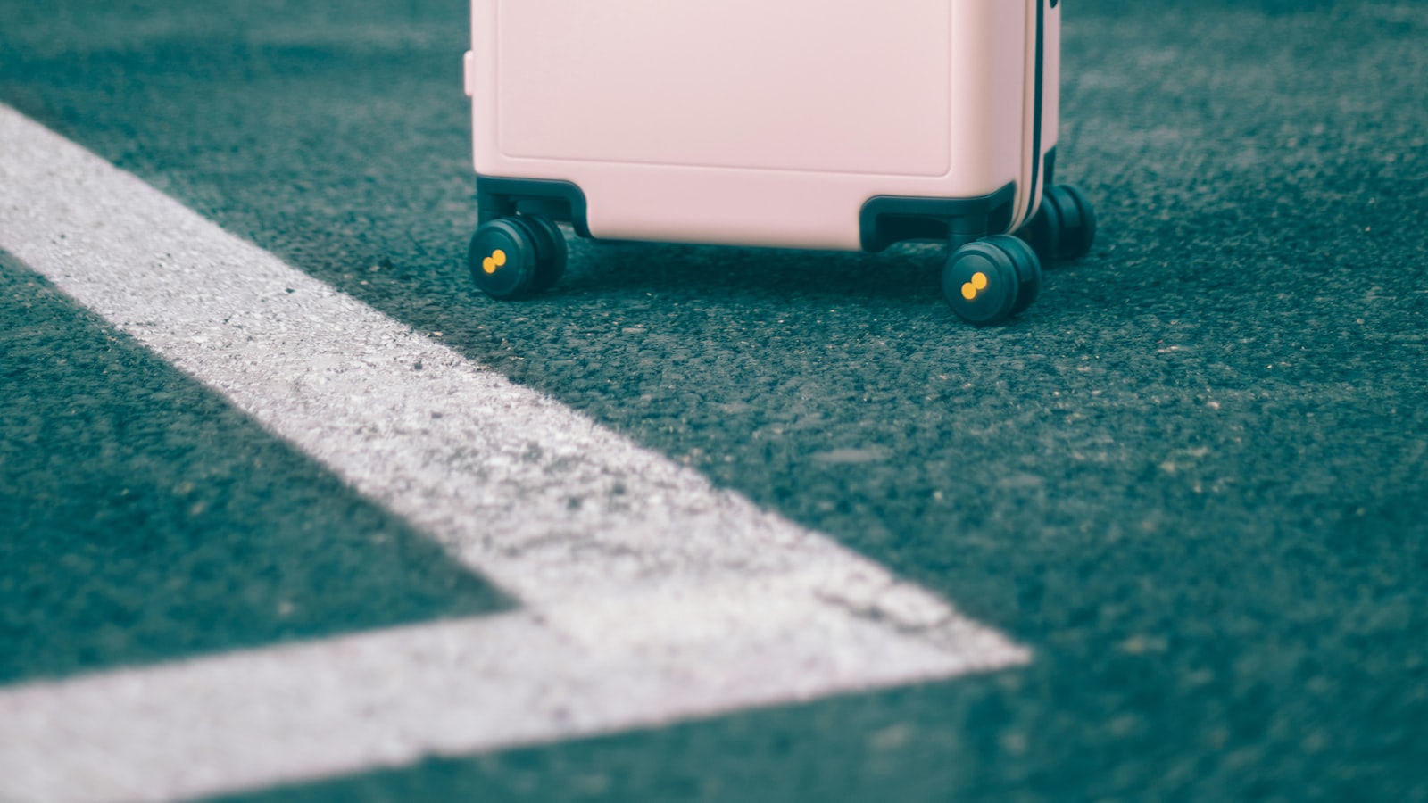 Six trousses de toilette ouvertes et alignées sur un plan de travail clair, flacons de voyage et sac plastique transparent posés devant