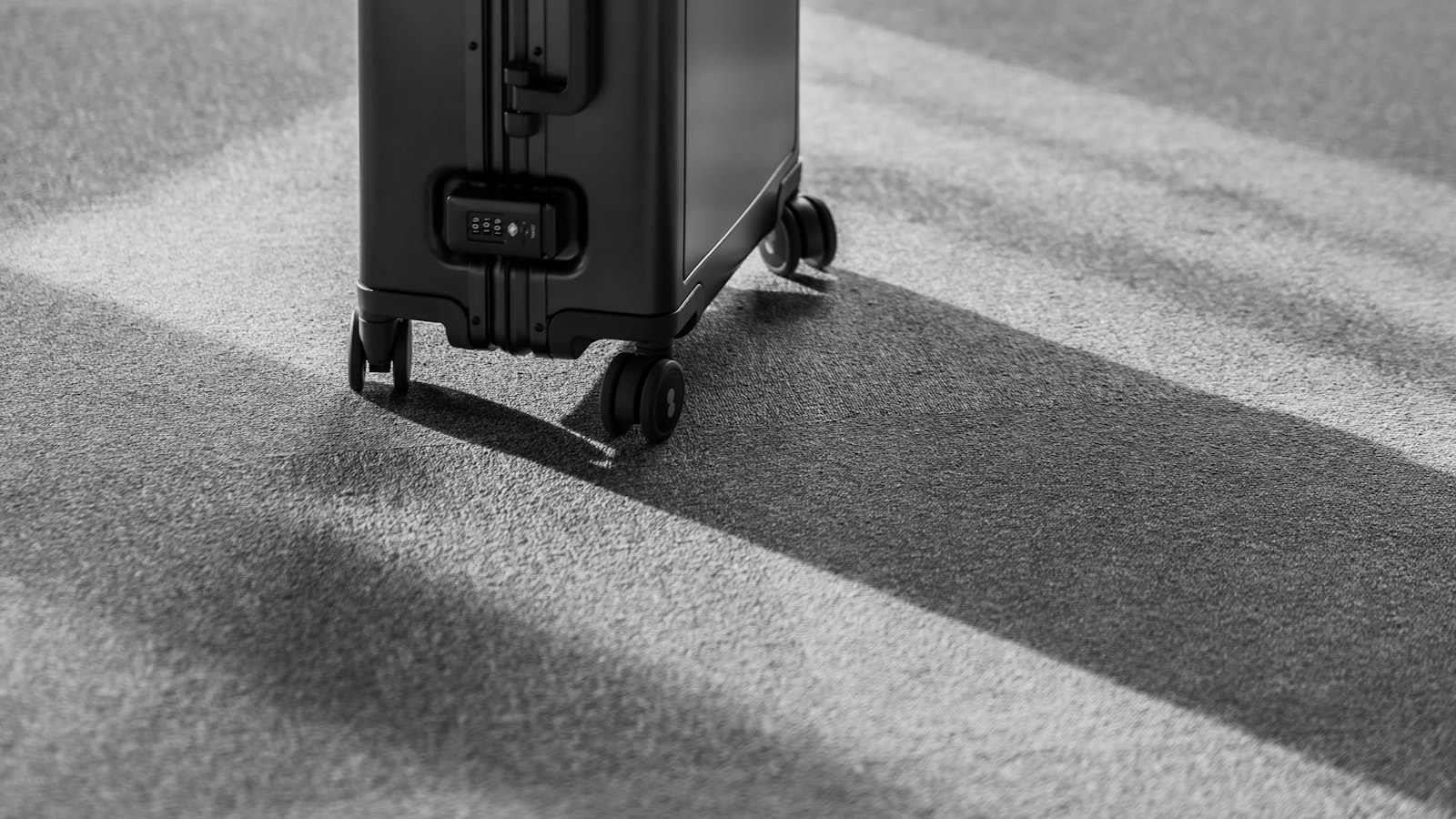 Contenu d'un sac professionnel étalé sur une table blanche : ordinateur portable, câbles, carnet, trousse, batterie externe, à côté d'une balance de cuisine numérique.